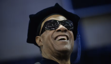 Stevie Wonder with sunglasses in graduation cap